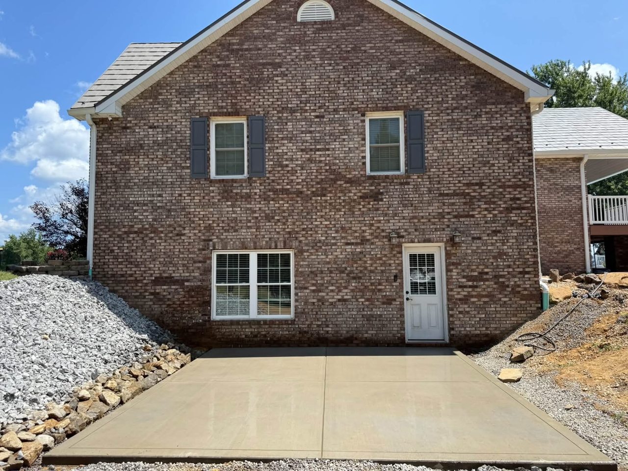 Completed concrete driveway beside a brick home